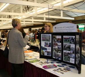 two people talking at a table with pictures of invasive plants