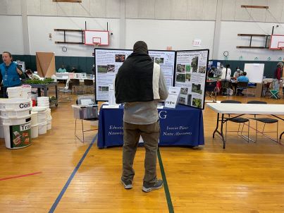 Man in front of CIPWG table at Hamden Earth Day celebration